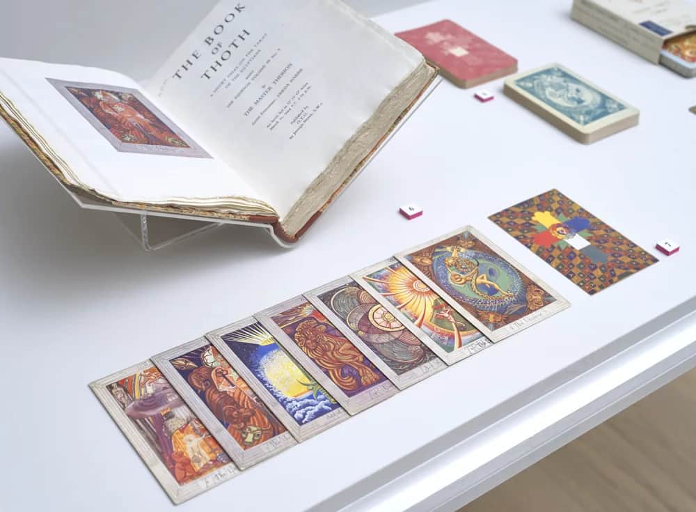 Warburg 展柜里打开的托特之书和并排陈列的塔罗牌